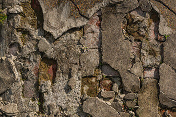 Cracked brickwork with broken shards of concrete pavement, which has come to look like this due to different weather conditions