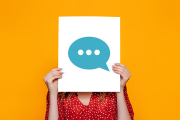 young woman holds blank speech bubble with dialogue isolated on an orange background