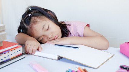 Portrait Of Cute Little Asian Female Child Sleeping At Desk Tired After Doing School Homework, Exhausted Girl Using Of Books As Pillow, Napping At Table At Home, Closeup Shot, Free Space.