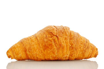 One freshly baked fragrant croissant, close-up, isolated on white.