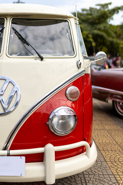 Volkswagen Kombi (VW Camper Bus) corujinha anos 60 vis&atilde;o frontal, vermelha e branca no encontro de carros antigos. Brasil