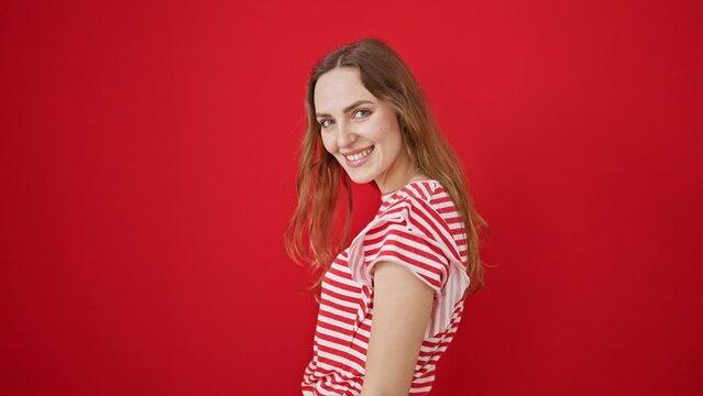Young blonde woman smiling confident standing over isolated red background