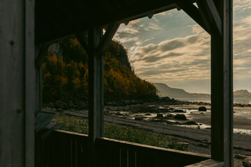 vue sur une falaise en automne en arrière plan vue à partir d'un refuge en bois à l'ombre lors d'un coucher de soleil