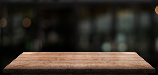 Empty wooden table top with lights bokeh on blur restaurant background.	