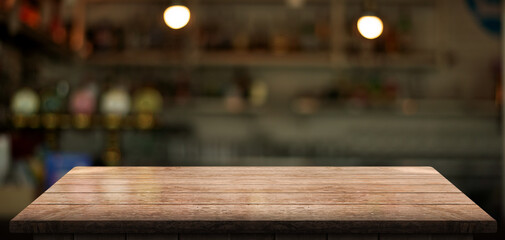 Empty wooden table top with lights bokeh on blur restaurant background.	