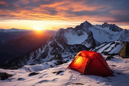 tent pitched on a snowy mountain with a sunrise backdrop