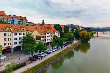 Fototapeta premium Aerial autumn landscape view of beautiful embankment of Drava River with colorful medieval buildings in Maribor. Famous touristic place and travel destination in Slovenia