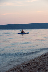 Aged beared and grey haired man swims on a sap in the sea at sunset. Beautiful calm cleaning of the...