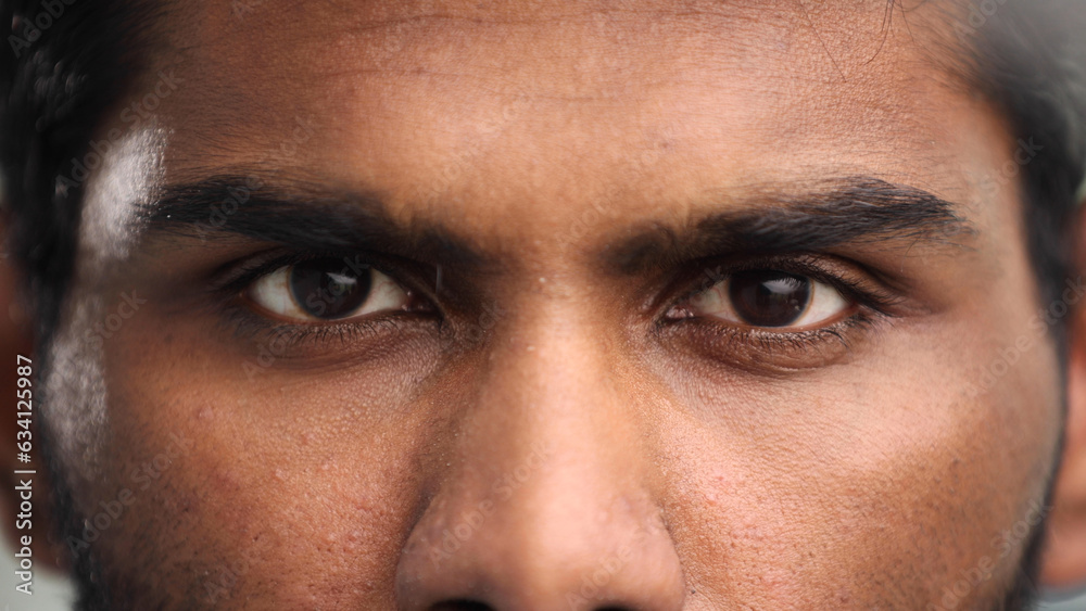 Wall mural close-up of the face and eyes of an indian man in an emotional pose, eyes open