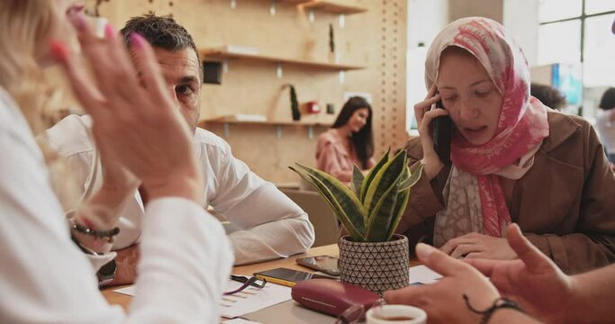 Colleagues with mixed age and religion discussing business ideas at the cafe shop in the office