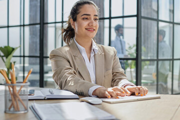 Photo of pretty young girl sitting at desktop computer in office indoors