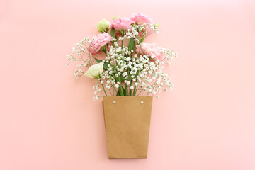 Top view image of delicate pink flowers over pastel background