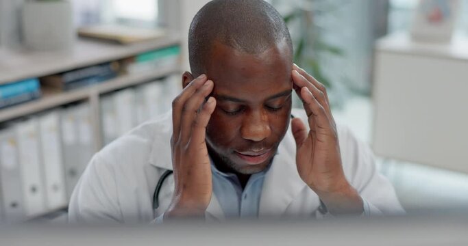 Healthcare, headache and computer with a doctor black man in a hospital, working on a negative report for diagnosis. Medical, anxiety or stress with a medicine professional looking tired in a clinic