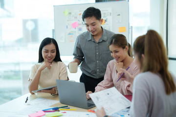 Group of asian creative teamwork discuss at business meeting for developing mobile phone app...