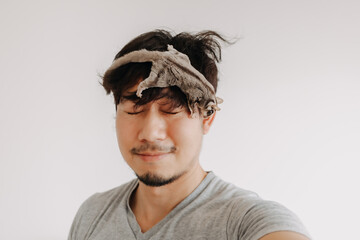 Close up of happy asian man with his Sugar Glider pet climbing around his head.