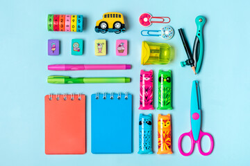 Stationary, back to school, creativity and education concept. Supplies - scissors, pencils, paper clips, note, stapler, calculator, notepad on green background