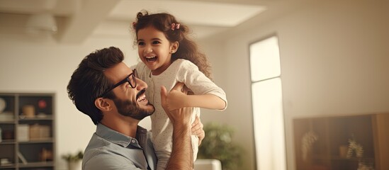 Middle eastern family playing together at home cheerful dad lifting up his joyful girl playing airplane copy space