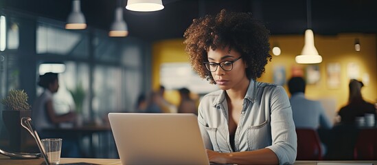 African American businesswoman in modern office busy on laptop