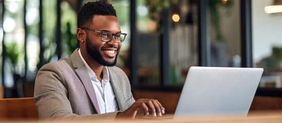 Close up of smiling African American freelancer typing on laptop enjoying remote job