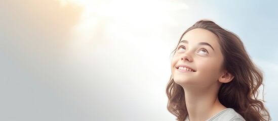 Teen girl looking up with a smile blank copy space over light background