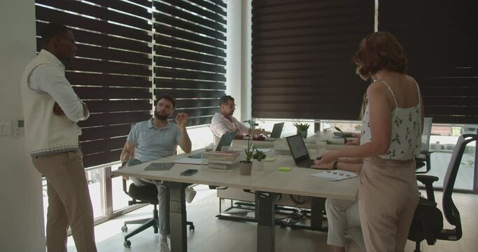 Diverse multirace and gender group of business professionals working together in the modern office, daytime, summer, trucking camera motion