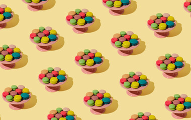 Creative colorful pattern made of various macarons on pastel yellow background. Minimal sweet food concept. Trendy macaron cookies pattern background.