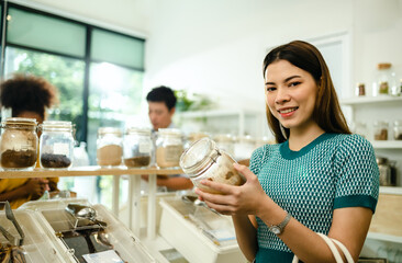 Woman Buying Cereals And Grains In Sustainable Plastic Free Grocery  and refill store with reusable bag.Environment-friendly, sustainable lifestyles.
