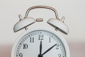 White vintage alarm clock shows 12 o'clock. Deadline time. Lunch and break time