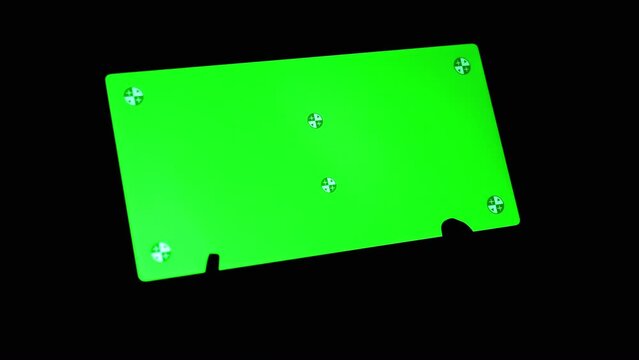 Smartphone with a Green Screen Rotates on a Black Background in the Dark Room. Empty space, a place for text. Markers. Gadget, a mobile phone with a glowing screen. Chrome kay background. Close up.
