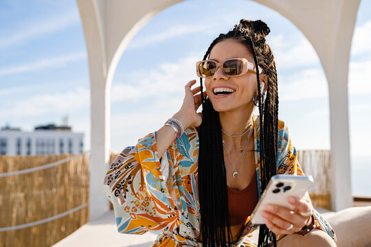 stylish mixed race woman with african braids on sunny summer vacation