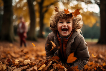 A joyful little boy playing in a pile of autumn leaves