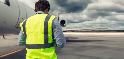 The inspector on the runway monitors the work on the aircraft