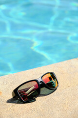 sunglasses on the background of the pool