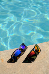 Fototapeta na wymiar sunglasses on the background of the pool