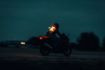 Biker in a burning jacket drive fast at night