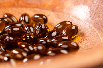Herbal capsules from medicinal cannabis plant. CBD pills in wooden bowl. Cannabidiol herb treatment