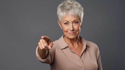 Senior woman wearing casual clothes pointing with hand and finger to the side looking at the camera.