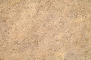Rough plastered wall painted with old beige paint, background