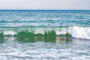 Naklejka na ściany i meble Rolling waves on seashore, close-up, at clear day