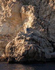 A rock-built lighthouse on Es Vedra illuminated by the sun
