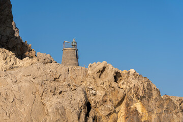 A rock-built lighthouse on Es Vedra illuminated by the sun