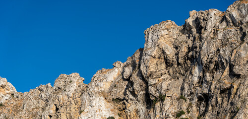 Close-up shot of Es Vedra Ibiza against a blue sky backdrop with sunlight