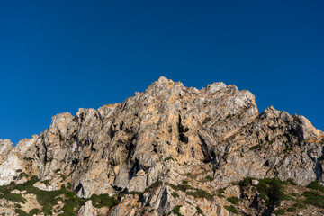 Close-up shot of Es Vedra Ibiza against a blue sky backdrop with sunlight