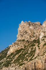 Close-up shot of Es Vedra Ibiza against a blue sky backdrop with sunlight