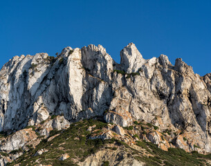 Close-up shot of Es Vedra Ibiza against a blue sky backdrop with sunlight
