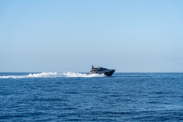 A high-speed yacht racing across the blue sky and sea
