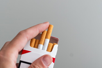 Pack of cigarettes in hand, isolated on white background
