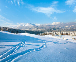 Fototapeta na wymiar Winter calm mountain landscape with sheds group and mount ridge behind (Kukol Mount, Carpathian Mountains, Ukraine)