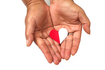 Hand holding a red and white paper heart love-shaped with empty copy space isolated on a white background, representing Indonesia Independence Day concept