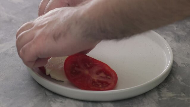 Laying on Plate Rings of Tomatoes and Mozzarella. Preparation of Italian Caprese Calad, Close-up